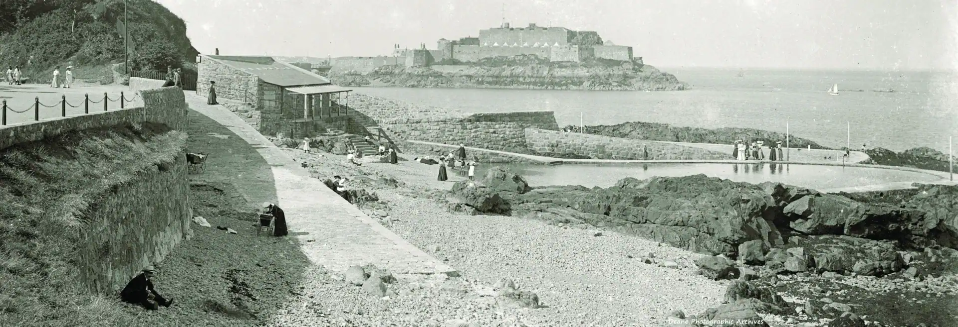 Historic bathing pools along the shoreline with rocky surroundings.