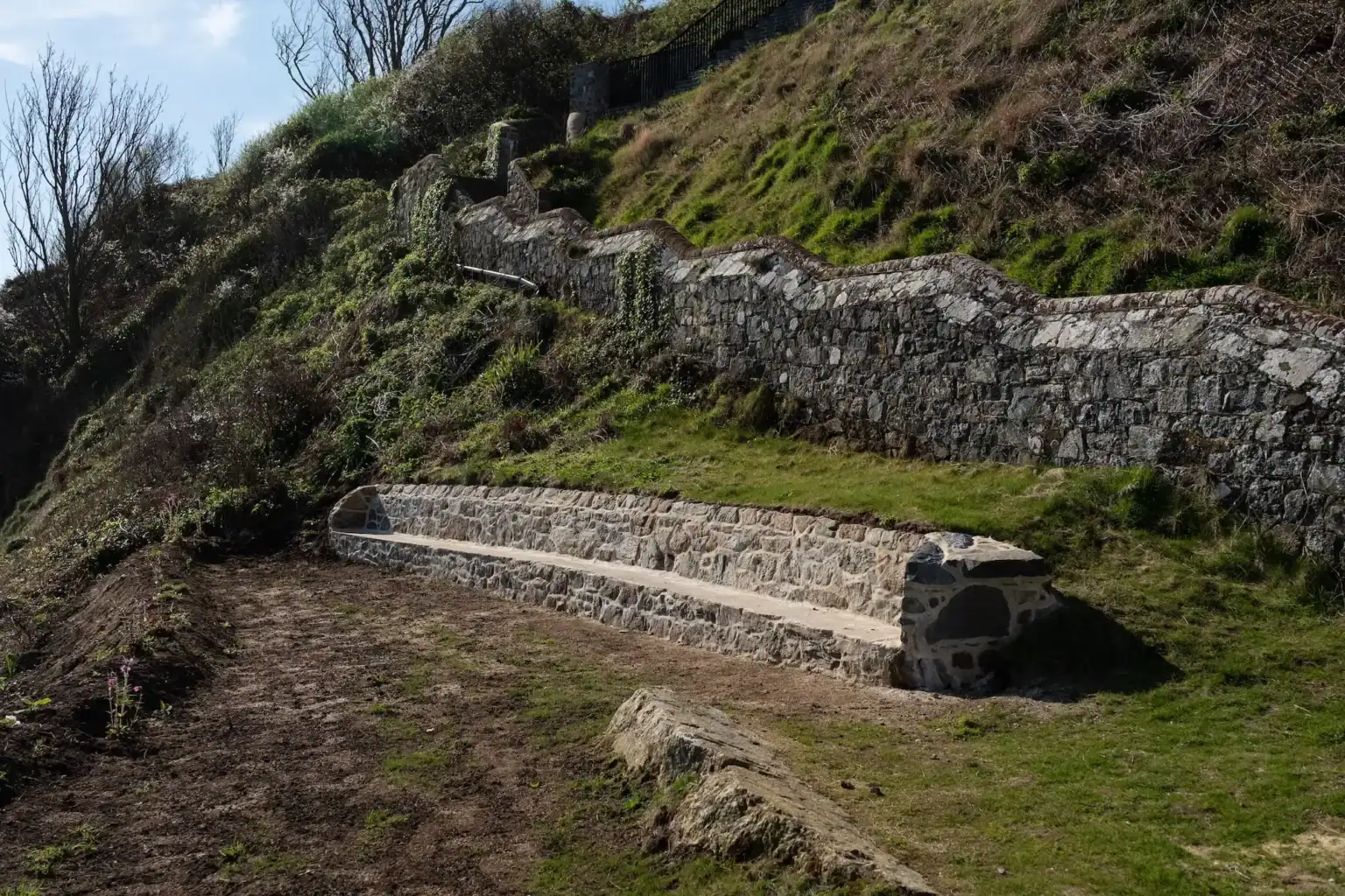 Historic stone bathing pools on a hillside with terraced levels and stone walls.